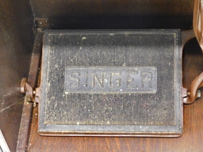 A 20thC Singer treadle sewing machine in oak cabinet, with articulated top and double front doors, 80cm high, 54cm wide, 42cm deep. - 4