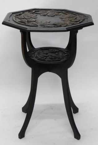 A heavily carved oak side table, raised with leaves, on shaped supports joined by a circular under tier, on fluted sabre legs, 79cm high, 61cm wide, 55cm deep.