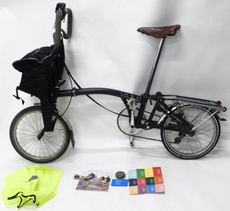 A Brompton folding bike, with Brooks saddle and front carrying bag etc, model P67,, 113cm high.