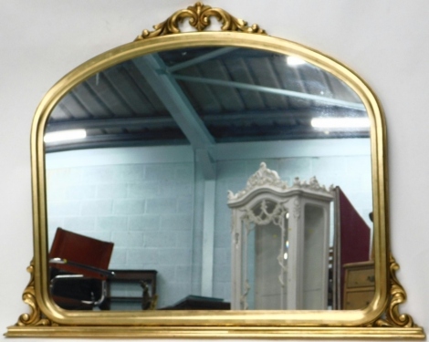 A gilt overmantel mirror, surmounted by scroll carving, the plain glass flanked by further scrolls, 113cm high, 112cm wide, 7cm deep.