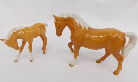 A Beswick pottery Palomino horse, right leg raised, printed marks beneath, 17cm high, and another foal. (2)