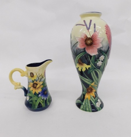 A 20thC Old Tupton ware pottery vase, tube lined with flowers, printed marks beneath, 28cm high, similarly decorated jug (2)