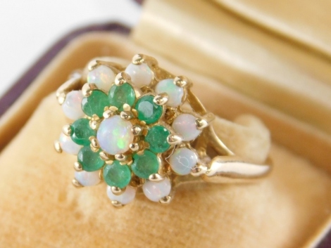 A 9ct gold cluster ring, of three layer design, set with opal and emerald, in a raised basket setting, ring size P, 3.6g all in, in a F Pearce's of Newington, Bucks box.