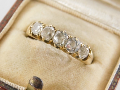 A five stone diamond set dress ring, with five old cut diamonds, of graduated size, the largest 0.15 carat, the smallest 0.05 carat, on a yellow metal rose gold band, unmarked, ring size S, 3.4g all in, in a Dyson and Sons of Slough box.