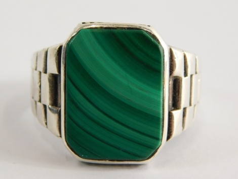 A malachite gent's signet ring, with rectangular panel in a rub over setting, with layered design shoulder, on a white metal band stamped 925, ring size Z½, 11.2g all in.