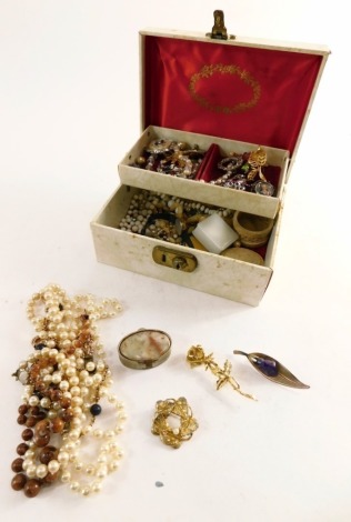 A cream leatherette jewellery box and contents, comprising dress brooches, faux pearl necklaces, miniature soapstone style trinket box, collectors coins, etc. (1 box)