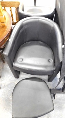 A pair of black leather tub chairs and footstools.