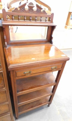 A late Victorian walnut music cabinet or whatnot, with a shaped back, single drawer and shelves.