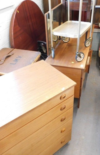 A Schreiber teak dressing table, five drawer chest, an Edwardian mahogany piano stool, and a two tier dinner wagon.