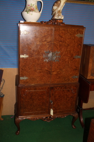 A burr walnut cocktail cabinet with cupboard below, on cabriole legs.