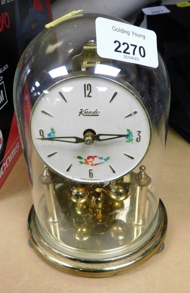 A Kundo brass anniversary clock, with glass dome, 18cm high.