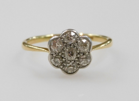 A diamond seven stone flower head ring, set in yellow and white metal, indistinctly stamped to the shank, approximately 0.45ct, size N, 2.1g.