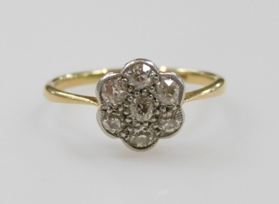 A diamond seven stone flower head ring, set in yellow and white metal, indistinctly stamped to the shank, approximately 0.45ct, size N, 2.1g.