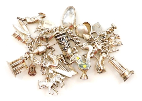 A silver curb link charm bracelet, on a heart shaped padlock clasp, with safety chain, and twenty charms as fitted, 75.2g.