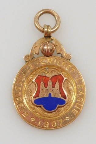 A 9ct gold and enamel cricketing medallion, for the Ribblesdale Cricket League 1907, with loop suspension, verso engraved Clitheroe CC, TD Bourn, 8.7g.