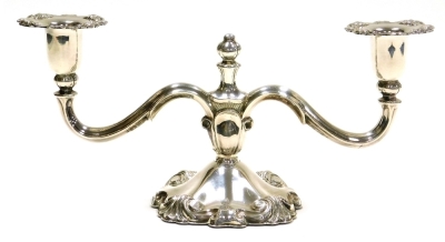 A Danish white metal candelabrum, with embossed scroll decoration to sconces and base, stamped 830 Cohr, loaded, 12cm high, 27cm wide.