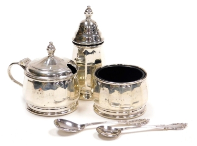 An Elizabeth II three piece silver cruet, comprising pepper pot, open salt with blue glass liner, mustard pot with blue glass liner, Birmingham 1965, together with an associated salt and mustard spoon, weighable silver 2.31g.