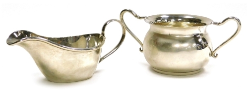 A Victorian silver two handled sugar bowl, of cauldron form, James Deakin & Sons (John & William F Deakin), Chester 1898, 2.43oz, 6cm high, together with an Elizabeth II silver cream boat, Albert Edward Jones, Birmingham 1969, 2.05oz, 5.5cm high, (2).