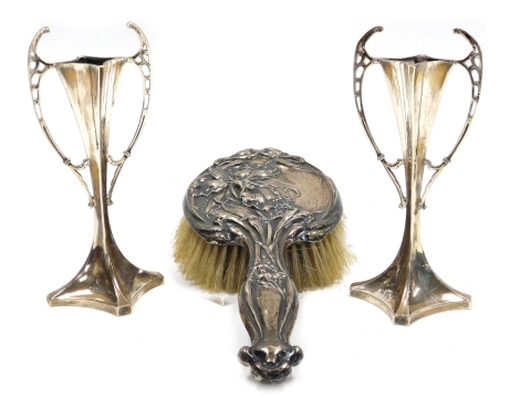 A pair of Edward VII Art Nouveau silver bud vases, of twin handled waisted form, loaded, Williams (Birmingham) Ltd, Birmingham 1908, 15cm high, together with a silver backed Art Nouveau style hair brush embossed with flowers, Birmingham 1886.