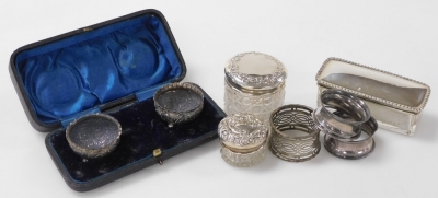 A group of small silver, to include a pair of Victorian silver open salts, embossed with flowers on three ball feet, in fitted case, three napkin rings and three cut glass dressing table bottles with silver lids, weighable silver 3.31oz.