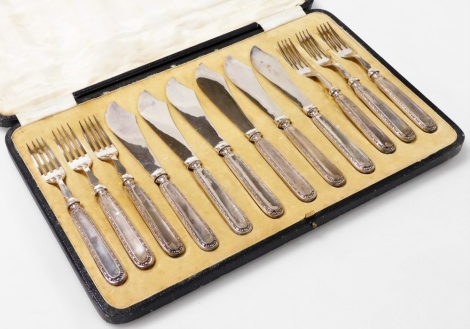 A set of six George V silver handled fish knives and forks, each handle with repeat raised decoration of beads and lozenges, with plated blades, Sheffield 1921, in fitted box.