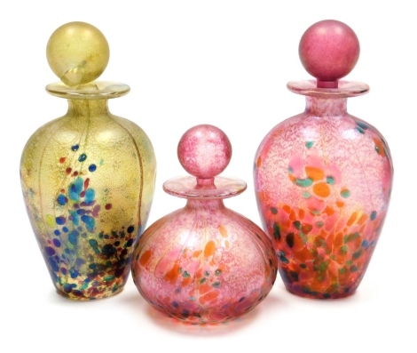 Three Isle of Wight glass 'Summer Fruits' scent bottles, designed by Timothy and Jonathan Harris, two in the cranberry colourway, one in the goldberry colourway (AF), unsigned, 13.5cm high (2) and 9cm high, all boxed.