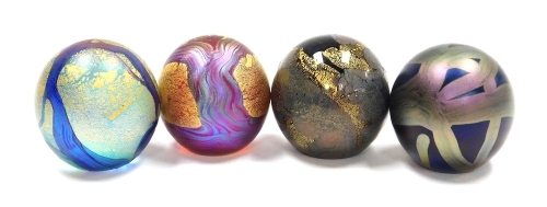 Four Isle of Wight glass orb paperweights, comprising a pair of purple paperweights with trailing decoration, gilt heightened, and two further paperweights, each with paper labels, 4.5cm high, boxed.