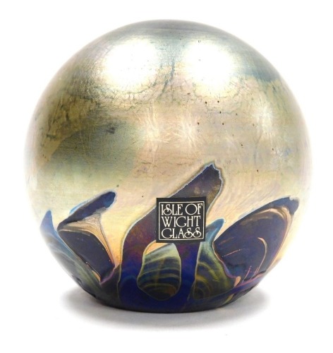 A Michael Harris Isle of Wight glass 'Nightscape' paperweight, of orb form, decorated with iridescent trails against a blue ground, with paper label, 7cm high.