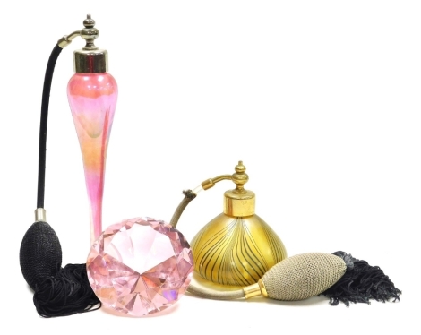 A Glasform iridescent glass scent bottle, of slender tapering form on a circular base, with atomiser, 21cm high, together with a further scent bottle with atomiser of squat globular form with trailing decoration against a gold coloured ground, 10cm high, 