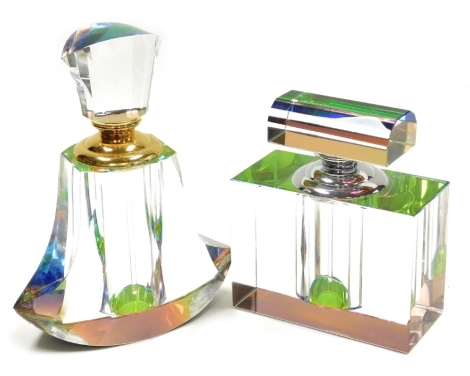 Two rainbow prism cut glass scent bottles, possibly by Hyaline & Dora, one of cuboid form with a faceted stopper, 12cm wide, the other of out swept faceted form, with a rhomboid stopper, 19cm high.