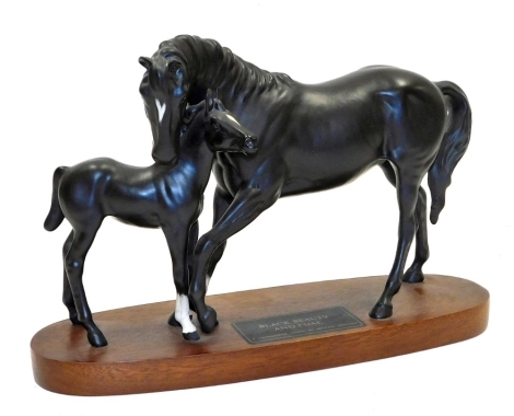 A Beswick Connoisseur model of Black Beauty and foal, on an oval hardwood base, 20cm high.