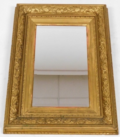 A 19thC gilt framed wall mirror, the border decorated in relief with flowers and leaves, with a central bevelled rectangular mirror plate, 78cm x 58cm.