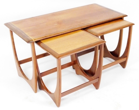 A mid century teak nest of three tables, each on a U shaped support, the largest 49cm high, 100cm wide, 49cm deep.