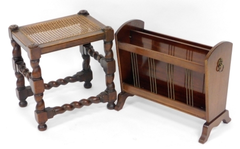 An early 20thC oak stool, with a caned top raised on turned legs united by two turned stretchers, 42cm high, together with a 20thC mahogany magazine rack. (2)