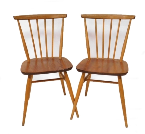 A pair of Ercol light elm kitchen chairs, each with a slatted back, solid seat, and tapering cylindrical legs, 78cm high.