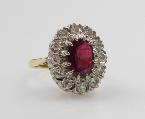 A ruby and diamond ring, the oval cut ruby and surround of diamonds, set in a white and yellow metal mount, stamped 18ct, ruby approximately 1ct, diamonds approximately ½ ct, size K, 5.4g.