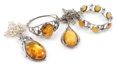 Silver and amber jewellery, comprising two pendants on chains, a bangle, and a six link bracelet on a snap clasp with safety chain as fitted. (4)