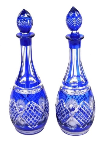 A pair of 20thC Bohemian blue flash glass decanters, with stoppers, 36cm high.