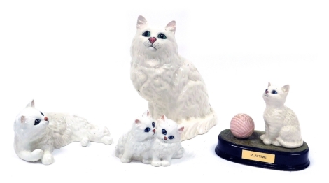 A group of Beswick pottery figures, modelled as white Persian cats, comprising the figure entitled Playtime, mounted on a hardwood base with presentation plaque, 13cm high, large standing cat, 20cm high, recumbent cat, 8cm high, and a pair of kittens, 8cm