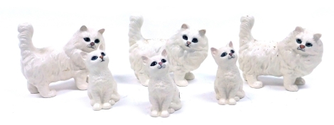 A group of Beswick pottery figures modelled as white Persian cats, comprising three standing cats, 13cm high, and three seated kittens, 11cm high.