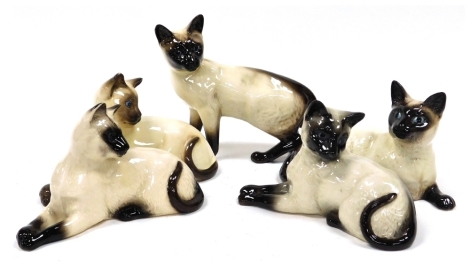 Five Beswick pottery figures modelled a Siamese cats, four in seated in position, and one standing.