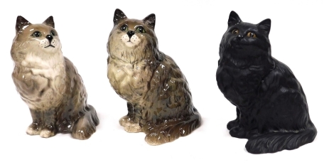 A pair of Beswick pottery figures modelled as grey cats, in seated poses, 21cm high, together with a further Beswick black matt pottery seated cat, 21cm high.