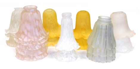 A group of frosted and other glass light shades, in pink, yellow, and white.