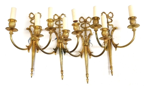 A set of four 20thC Adam style gilt metal two branch wall lights, each surmounted by a decorative bow, 43cm high.