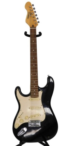 An Encore left handed electric guitar, with black and cream body.