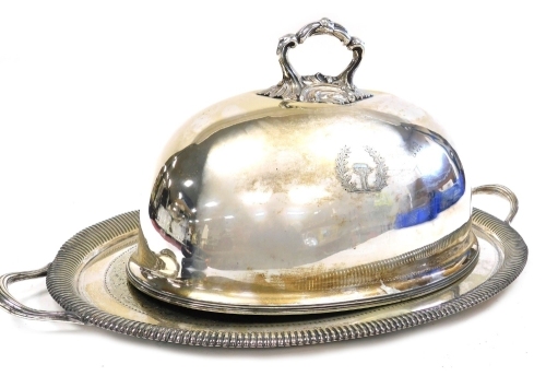 A Victorian Goldsmiths Alliance Limited silver plated meat dome, crest engraved, impressed marks, 30cm high, 46cm wide, together with a twin handled silver plated tray, with engraved decoration, central shield reserve crest engraved, 69cm wide. (2)