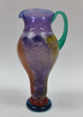 A Kosta Boda pitcher, by Kjell Engman, with vary coloured decoration, etched mark to base and numbered 89147, 32cm high, together with two graduated candlesticks by Kjell Engman, similarly decorated, etched marks, 26cm and 17cm high respectively. (3) - 2