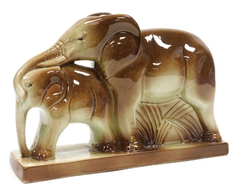 An early 20thC French pottery figure group, by Charles Lemanceau, of a mother and baby elephant, raised on a rectangular base, 34cm wide.