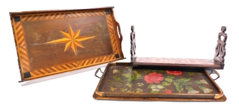 A Victorian mahogany book slide, with carved ends, 49cm wide, mahogany and inlaid twin handled tray, 52cm wide, and a further twin handled tray carved and stained with roses, shamrocks and thistles, 57cm wide. (3)