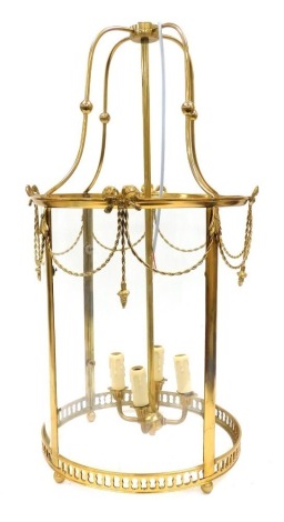 A circular brass framed hall lantern, of four branch form, with curved glass panels, one lacking, 83cm high.